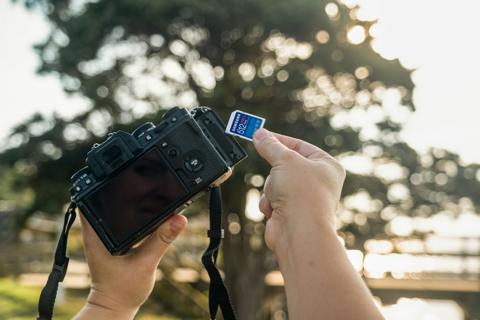 Hands inserting memory card into digital camera